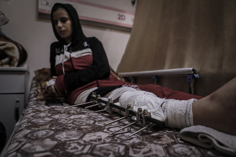 Ahed's bolted and bandaged leg lies in front of her on her hospital bed, immobilising her