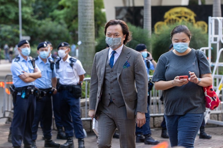 Barrister and pro-democracy activist Lawrence Lau arriving at court. He is wearing a three piece suit with blue tie and a matching silk handkerchief in his top pocket.