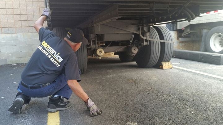 Bending over or crouching down to take a look under the vehicle during a driver inspection can catch problems not otherwise visible. - Photo: Transervice