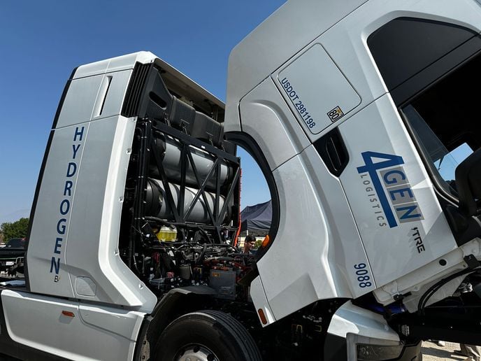 White Nikola hydrogen fuel cell truck with cab tipped to reveal engine