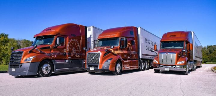 Three Arka Express tractor-trailers, Freightliner, Volvo, and Peterbilt