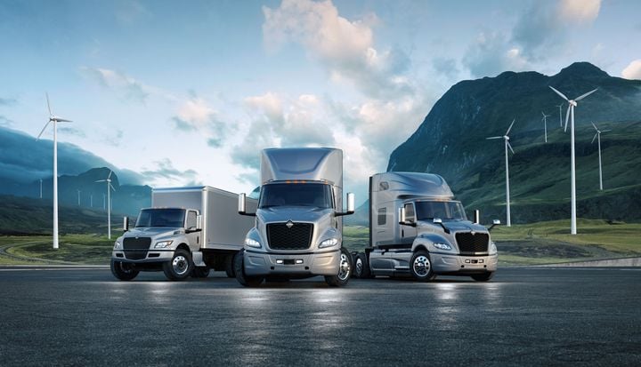 Navistar International electric trucks with wind turbines in background