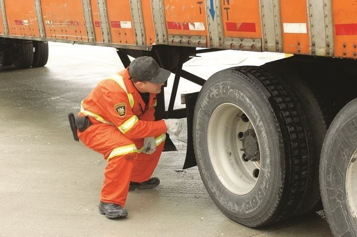 DOT officer inspecting a truck.