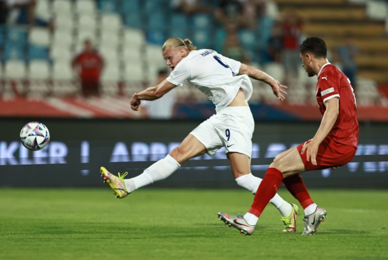 Player kicks football during match.