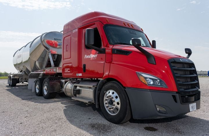 Red Freightliner Foodliner truck pulling bulk tanker trailer