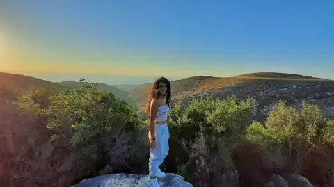 Maria Shaya Maria Shaya standing on a rock overlooking a beautiful valley in August 2020