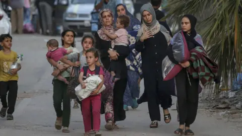 EPA Displaced Palestinians flee Bureij refugee camp, in the central Gaza Strip, following the start of an Israeli military ground operation 