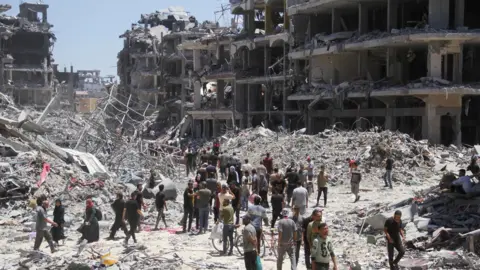 Reuters Palestinians make their way back to Jabalia after the withdrawal of Israeli forces, in the northern Gaza Strip (31 May 2024)