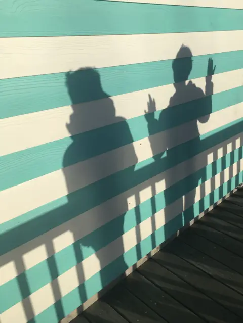 Neil Marsden The shadows of two people on a striped wall