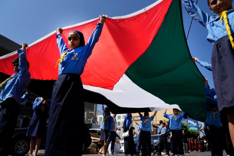 Palestinian scouts carry their national flag, as the march during the 40th anniversary commemoration of the Sabra and Shatila massacre, in Beirut, Lebanon, Friday, Sept. 16, 2022. During the Israeli's invasion of Lebanon in 1982, Palestinian men, women and children were massacred by forces identified as Lebanese Christian militiamen in west Beirut's Sabra and Shatila refugee camps. The official toll is 328 confirmed killed, 991 missing. (AP Photo/Bilal Hussein)