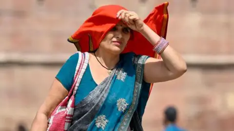 Getty Images A woman covers her face in the heat 