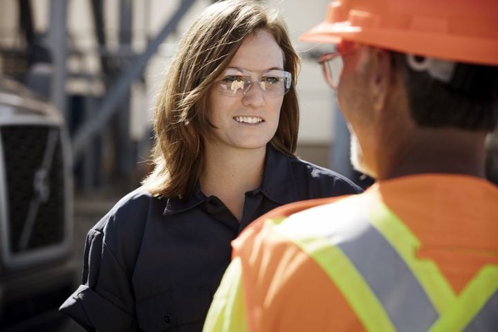 Woman truck driver talking to a worker.