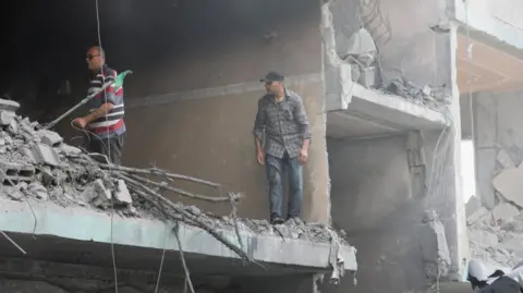 Reuters Palestinians inspect a house hit in an Israeli strike, due to an Israeli military operation, amid the Israel-Hamas conflict, in Nuseirat refugee camp in the central Gaza Strip