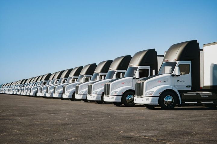 A row of new Peterbilt Model 579EV electric trucks.