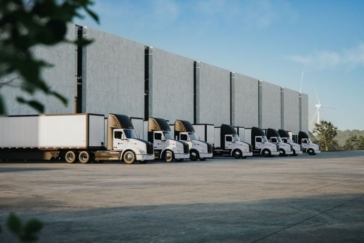 Peterbilt Model 579EV electric trucks parked at a warehouse.