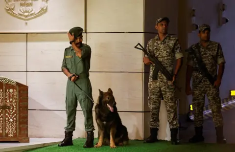 Reuters Security guards patrol the residence of Mukesh Ambani during the haldi function of Anant Ambani and Radhika Merchant before