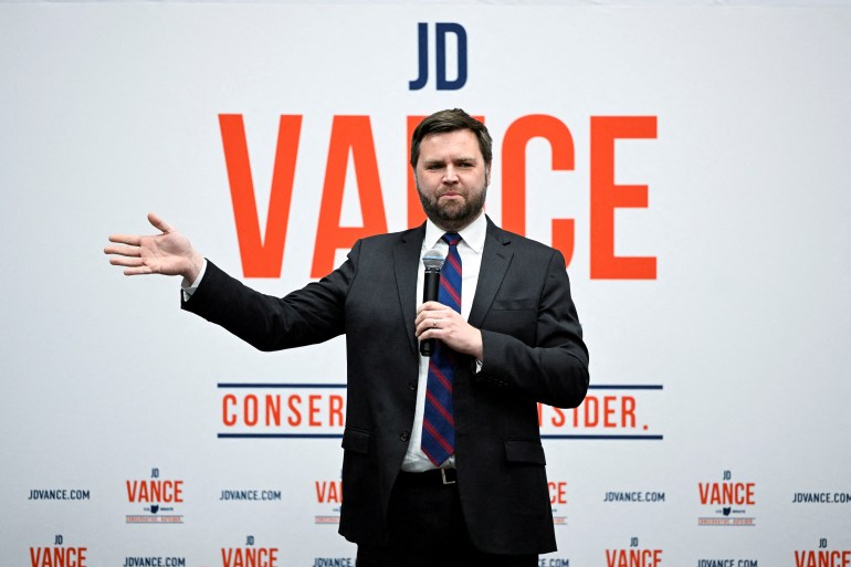 JD Vance campaigns in front of a sign that has his name and the words "Conservative Outsider."