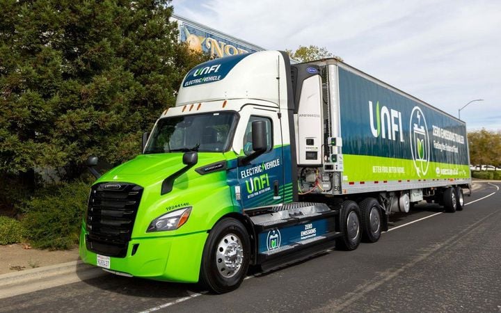 Green UNFI tractor-trailer with refrigeration unit (TRU)