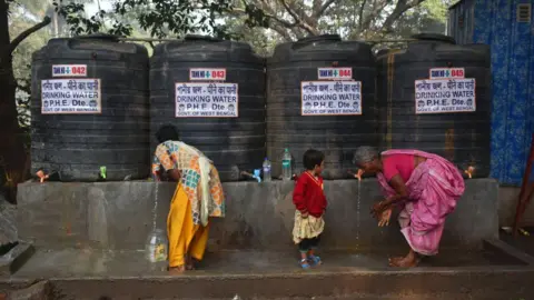 Getty Images People drink from water tanks in Kolkata