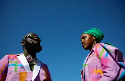 ROGAN WARD/REUTERS A man and a woman wear brightly dressed clothing.