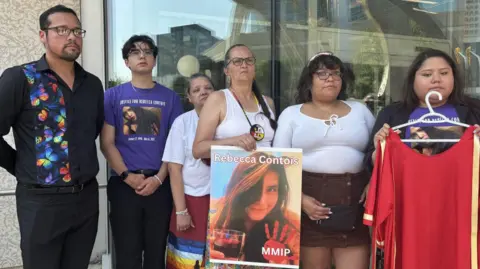 BBC Family of Rebecca Contois hold up her photo outside a Winnipeg courthouse following Friday's verdict 