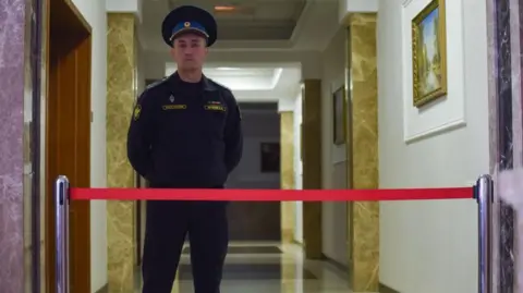 EPA-EFE/REX/Shutterstock  A bailiff stands guard in the court during hearing a case against the Wall Street Journal (WSJ) correspondent Evan Gershkovich in Yekaterinburg's Sverdlovsk Regional Court