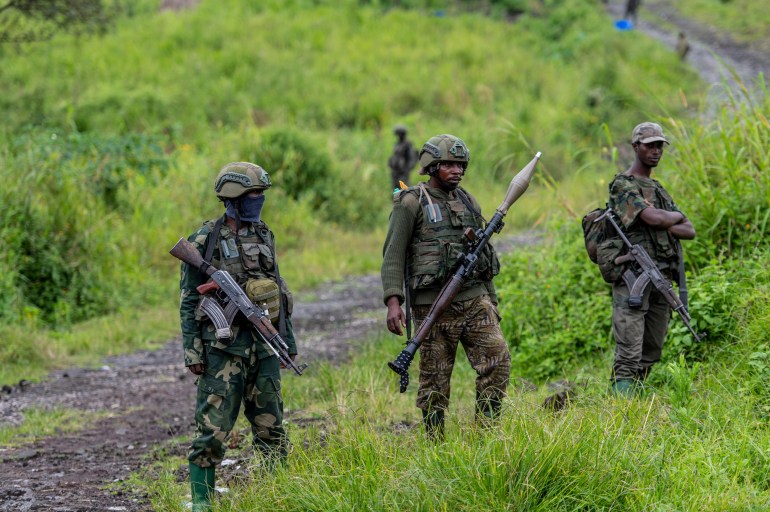 FILE - A M23 rebels stand with theirs weapons during a ceremony to mark the withdrawal from their positions in the town of Kibumba, in the eastern of Democratic Republic of Congo, on Dec. 23, 2022. The accounts are haunting. Abductions, torture, rapes. Scores of civilians including women and children have been killed by the M23 rebels in eastern Congo, according to a U.N. report expected to be published this week. (AP Photo/Moses Sawasawa, File)