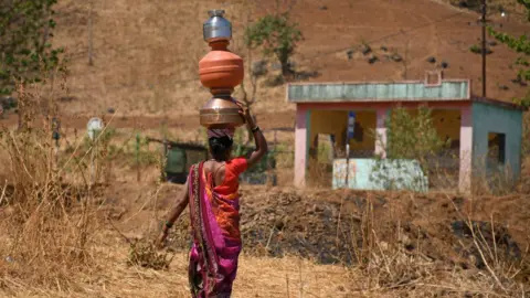 Getty Images A woman in India carries water on her head