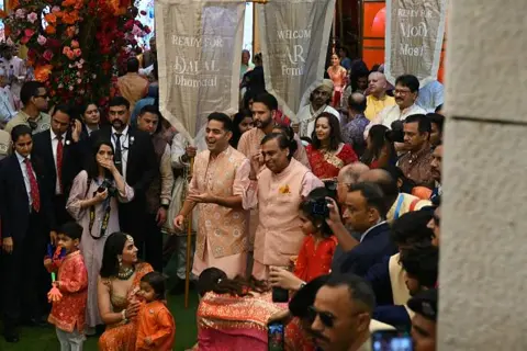 Getty Images Billionaire tycoon and Chairman of Reliance Industries Mukesh Ambani (centre R) alongwith his family attends a traditional wedding ritual ahead of the wedding of his son Anant Ambani to Radhika Merchant, at his residence Antilia in Mumbai on July 3, 2024. 