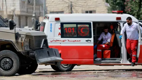 Reuter An ambulance and a police vehicle stand during an Israeli raid in Jenin, in the Israeli-occupied West Bank, 31 August