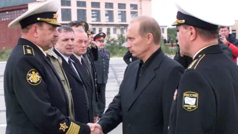 Getty Images Vladimir Putin shakes hands with Russian Navy Commander Vladimir Kuroyedov (L) after the sinking of the Kursk submarine in 2000