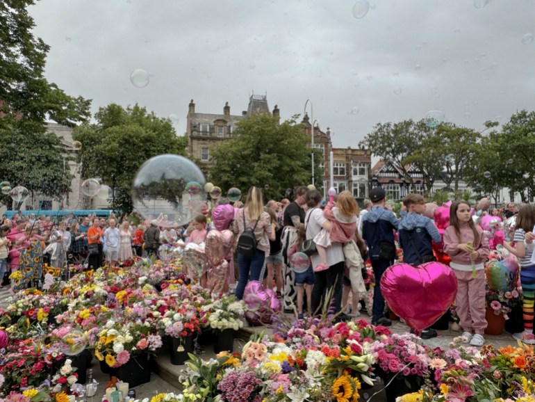 People blow bubbles at the "Kisses to Heaven" tribute to the victims of a knife attack, in Southport, Britain, August 5, 2024. REUTERS/Kirsten Donovan