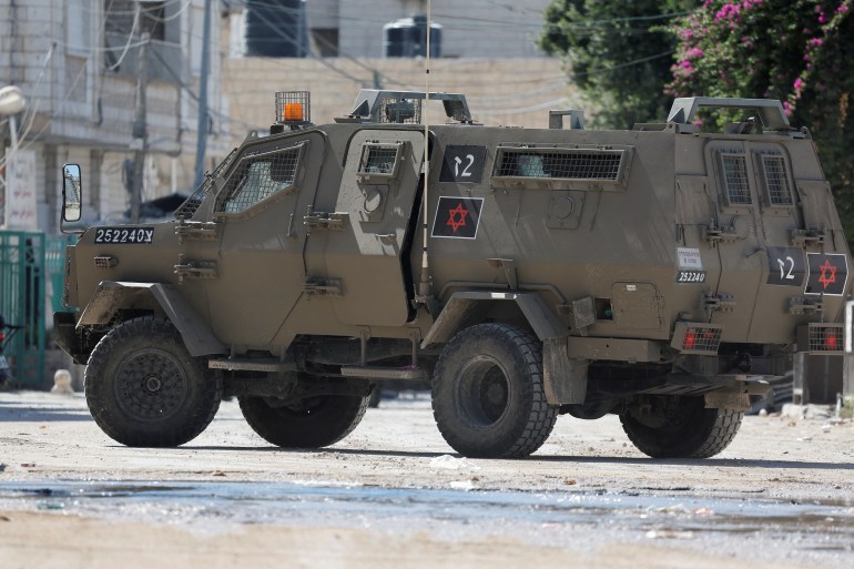 An Israeli military vehicle takes part in a raid, in Jenin,