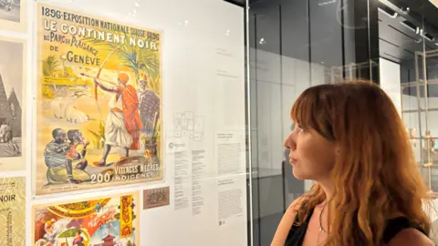 Imogen Foulkes Letizia Pinoja views a vintage poster at the exhibition exploring Switzerland's colonial past