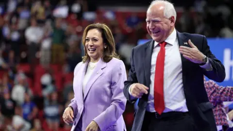 AFP Kamala Harris (L) and Minnesota Governor  Tim Walz gesture during a campaign rally in Las Vegas, Nevada