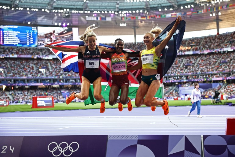 Bronze medallist Britain's Georgia Bell, gold medallist Kenya's Faith Kipyegon and silver medallist Australia's Jessica Hull celebrate after competing in the women's 1500m final of the athletics event at the Paris 2024 Olympic Games at Stade de France in Saint-Denis, north of Paris, on August 10, 2024. (Photo by Anne-Christine POUJOULAT / AFP)