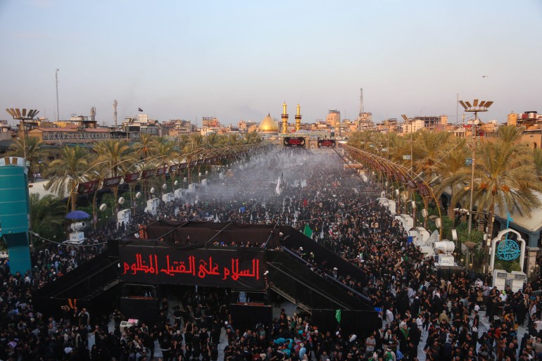 Shiite Muslim devotees gather between the shrines of Imam Abu Al-Fadl Al-Abbas (background) and Imam Hussein (not pictured) in Iraq's central holy city of Karbala on August 24, 2024, during Arbaeen commemorations marking the end of the 40-day mourning period for the seventh century killing of the Prophet Mohamed's grandson Imam Hussein Bin Ali. (Photo by Mohammed SAWAF / AFP)