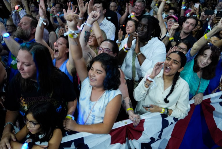 Harris supporters raise their arms as the nominee speaks