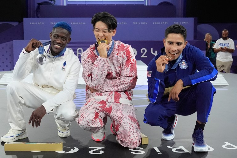 Gold medallist Canada's Philip Kim, known as B-Boy Phil Wizard, center, poses with silver medallist France's Danis Civil, known as B-Boy Dany Dann, left, and bronze medallist United States Victor Mantalvo, known as B-Boy Victor after the B-Boys finals in the breaking competition at La Concorde Urban Park at the 2024 Summer Olympics, Saturday, Aug. 10, 2024, in Paris, France. (AP Photo/Frank Franklin II)