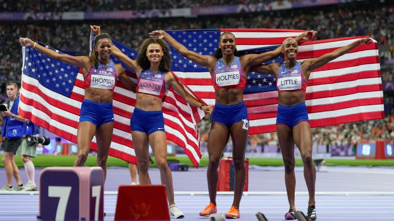 Gabby Thomas, Sydney Michelle McLaughlin, Alexis Holmes and Shamier Little, of the United States, pose after winning the gold medal in the women's 4 x 400 meters relay final at the 2024 Summer Olympics, Saturday, Aug. 10, 2024, in Saint-Denis, France. (AP Photo/Ashley Landis)