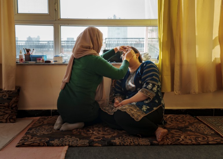 Sabba, 27, has her eyebrows waxed at home by Leila, her beautician. [Sandra Calligaro/Al Jazeera]