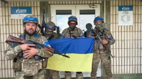 Unknown Ukrainian soldiers seen at a Gazprom gas facility in the Russian town of Sudzha - the location of the video recording has been verified by the BBC