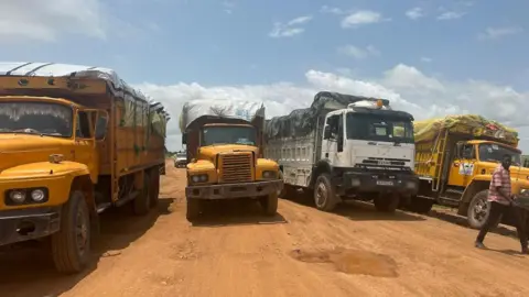 IOM / REUTERS Aid trucks with relief material for Sudan's Darfur region, at a location given as the border of Chad and Sudan.