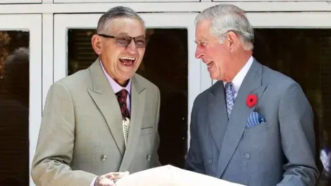 AFP Then-Prince Charles and King Tuheitia laugh as they exchange a gift 