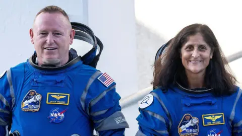 EPA Two smiling astronauts in blue space suits