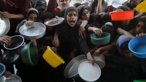 Reuters Gaza residents cry out for food at a charity kitchen