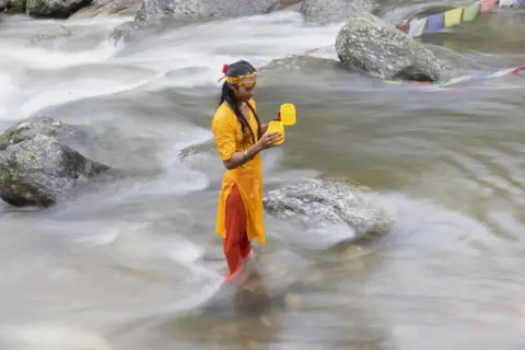 Narendra Shrestha / EPA-EFE A Nepalese Hindu pilgrim takes a holy dip and collects water from the Bagmati River to worship Shiva