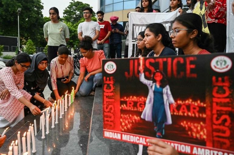 Medical professionals light candles as they pay tribute to a victim of the rape and murder of a young medic from Kolkata, in Amritsar on August 18, 2024 [Narinder NANU / AFP]