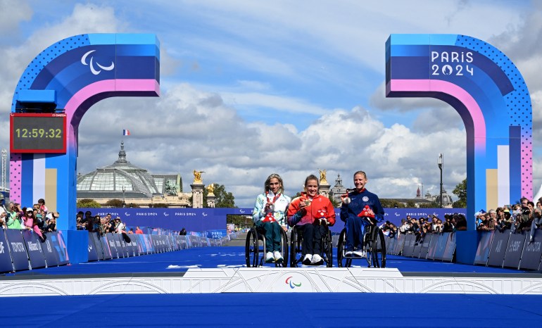 Paris 2024 Paralympics - Athletics - Women's Marathon - T54 - Victory Ceremony - Paris, France - September 8, 2024 Silver medallist Madison de Rozario of Australia, Gold medallist Catherine Debrunner of Switzerland and Bronze medallist Susannah Scaroni of United States pose on the podium REUTERS/Jennifer Lorenzini