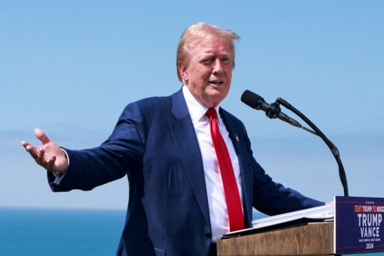 Donald Trump speaks at an outdoor podium in California.